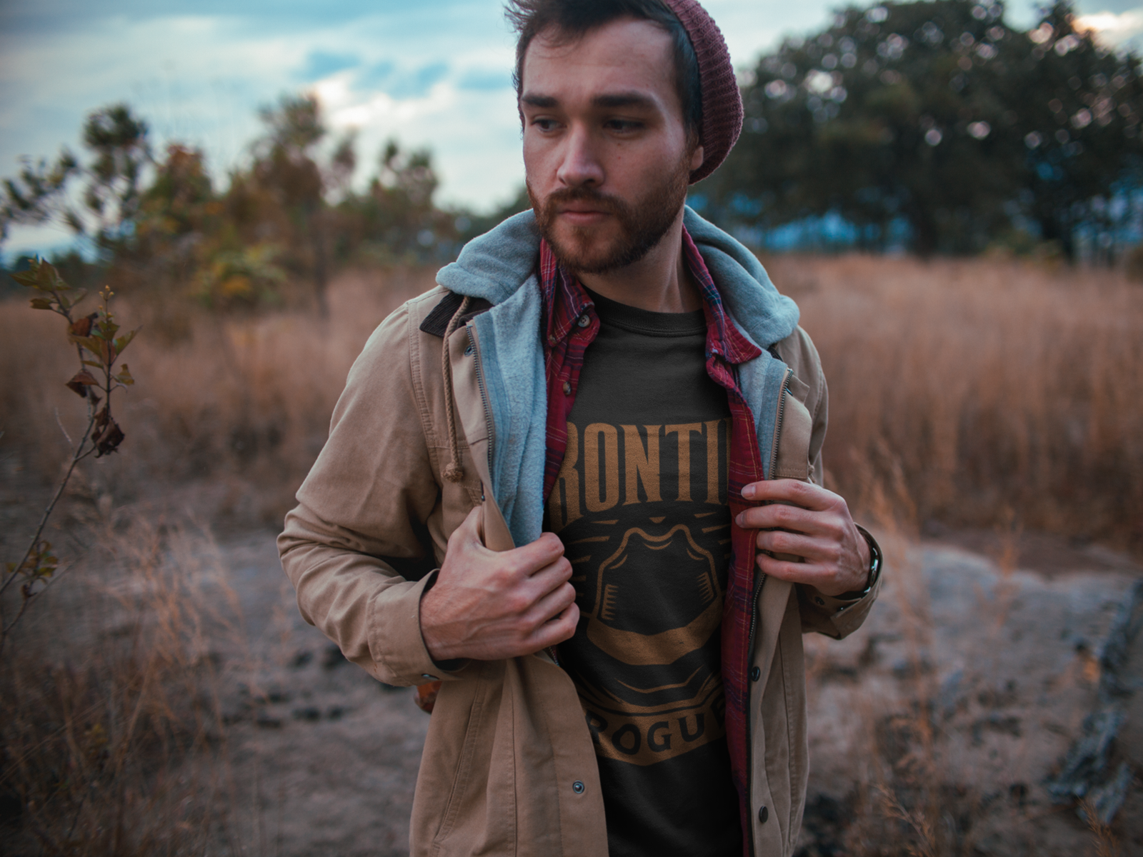 Man wearing Frontier Rogue logo graphic tee in outdoor setting